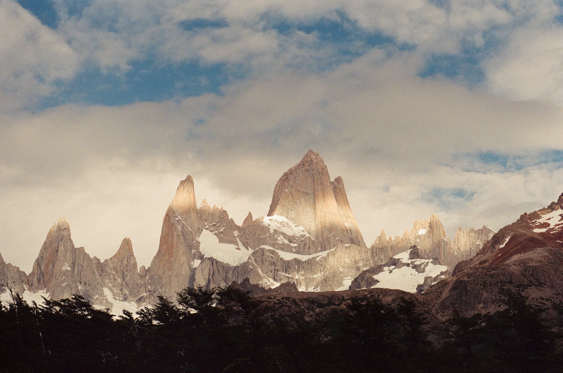 Snow-covered mountain peaks beneath pale clouds
