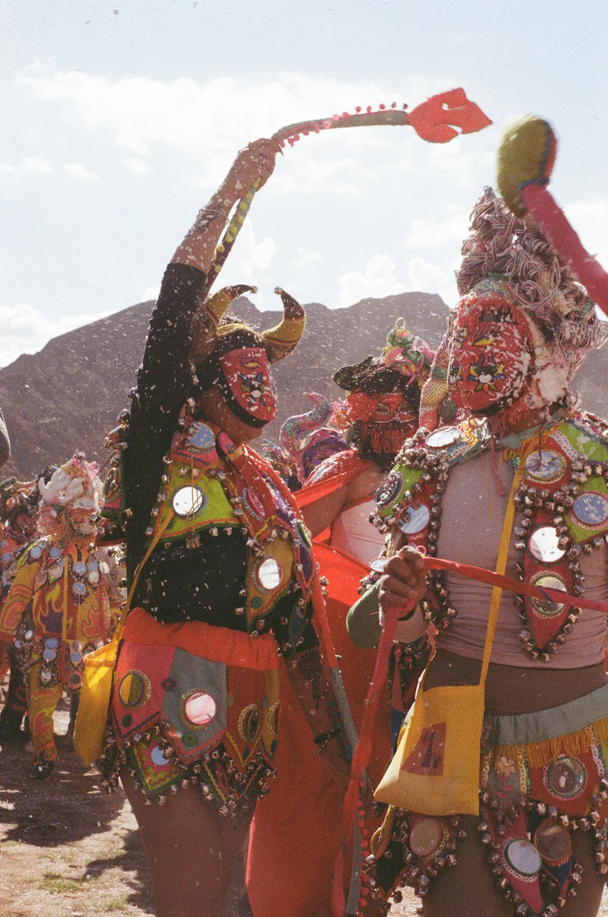 Costumed performers lifting their arms into sunlight