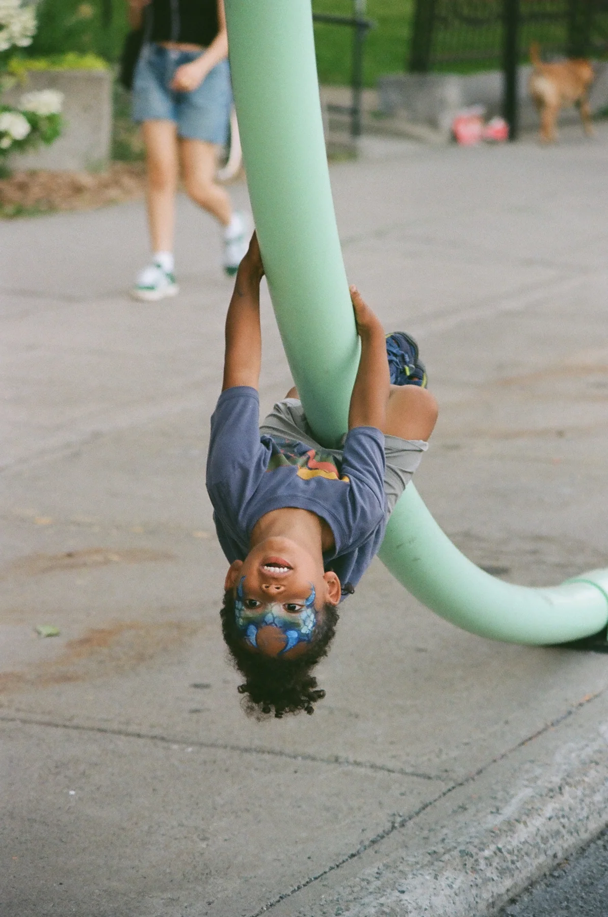 A performer draped across a curved green form