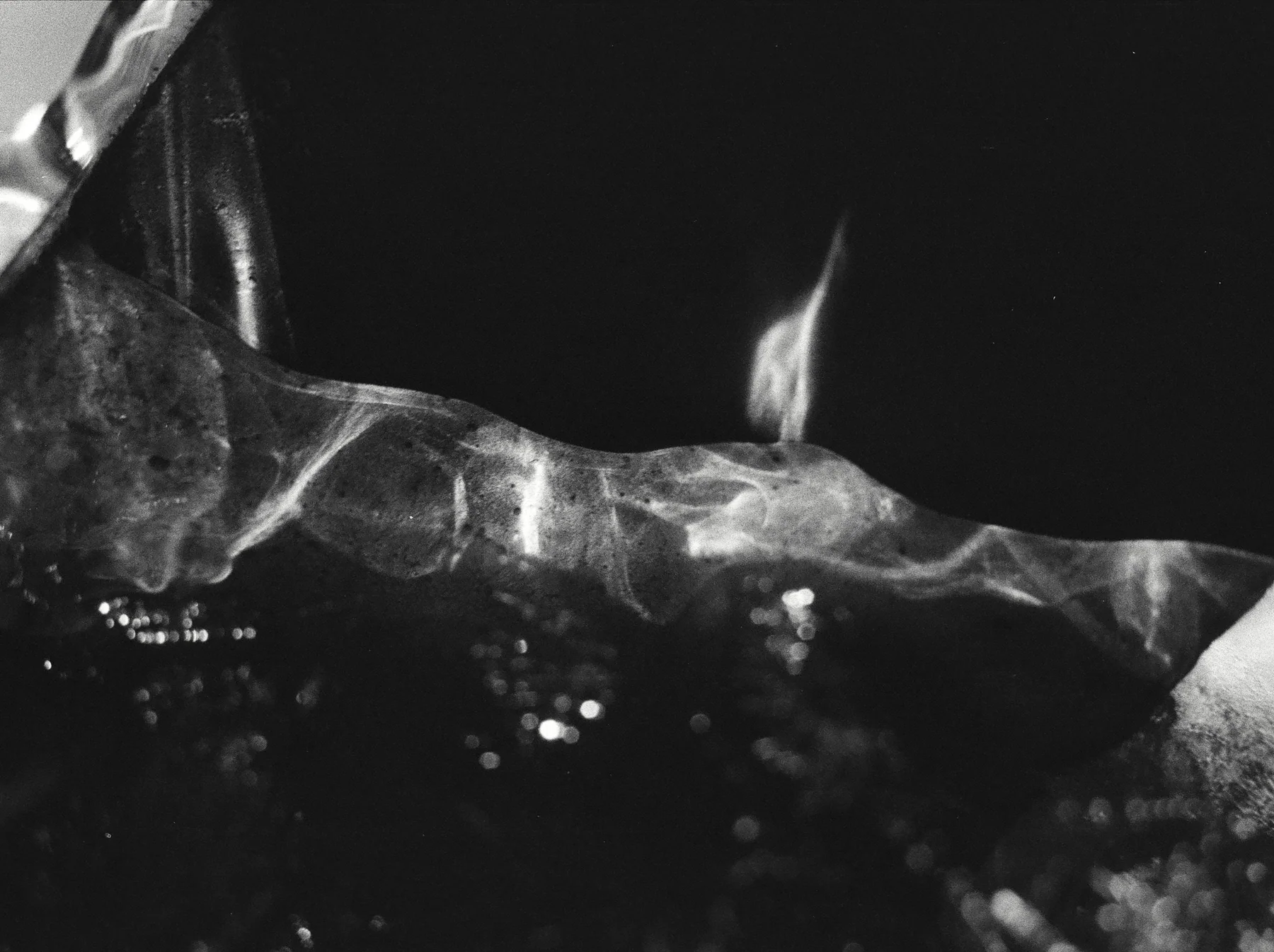 Reflections moving across the edge of a dark glass object