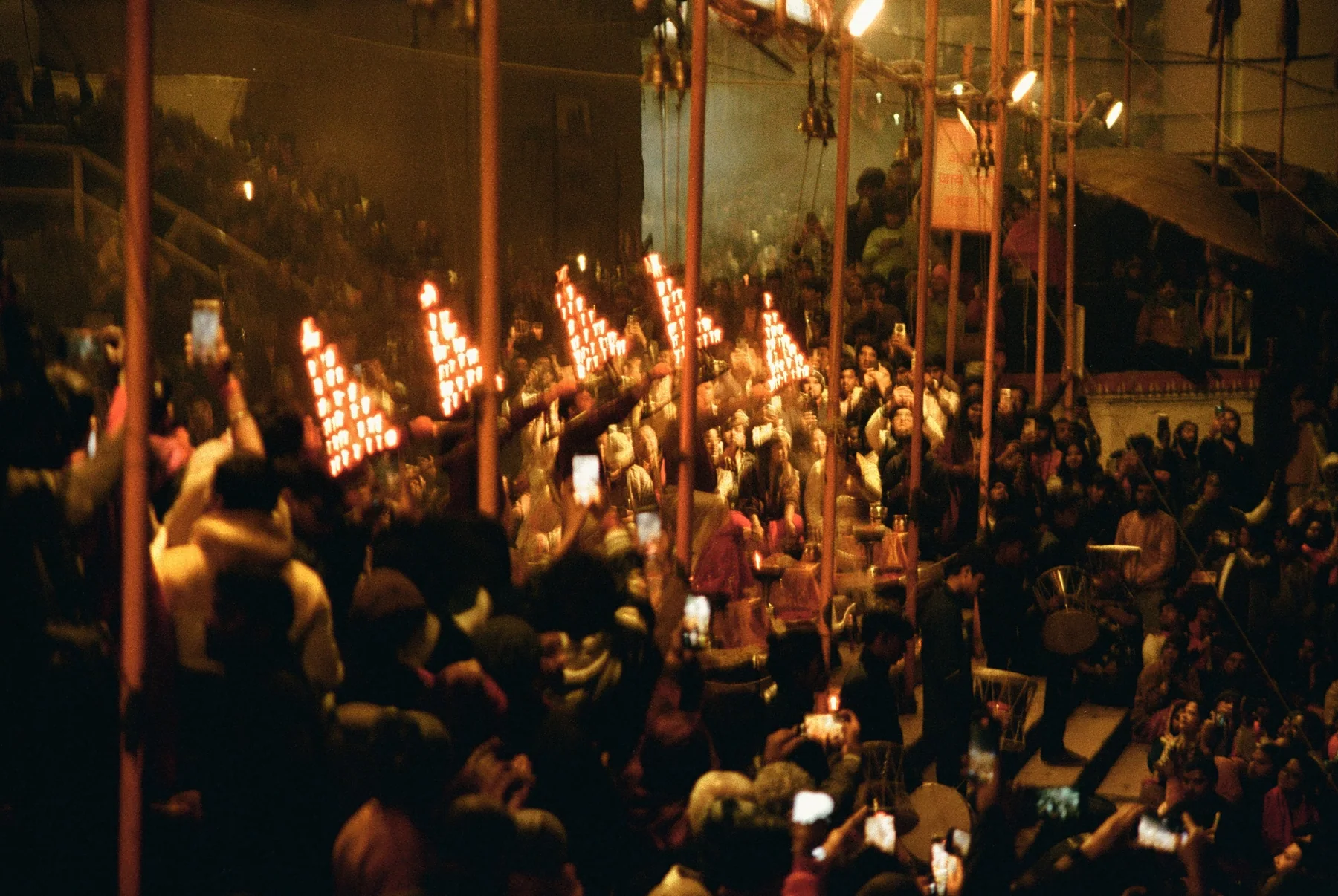A tightly packed crowd illuminated by warm stage light