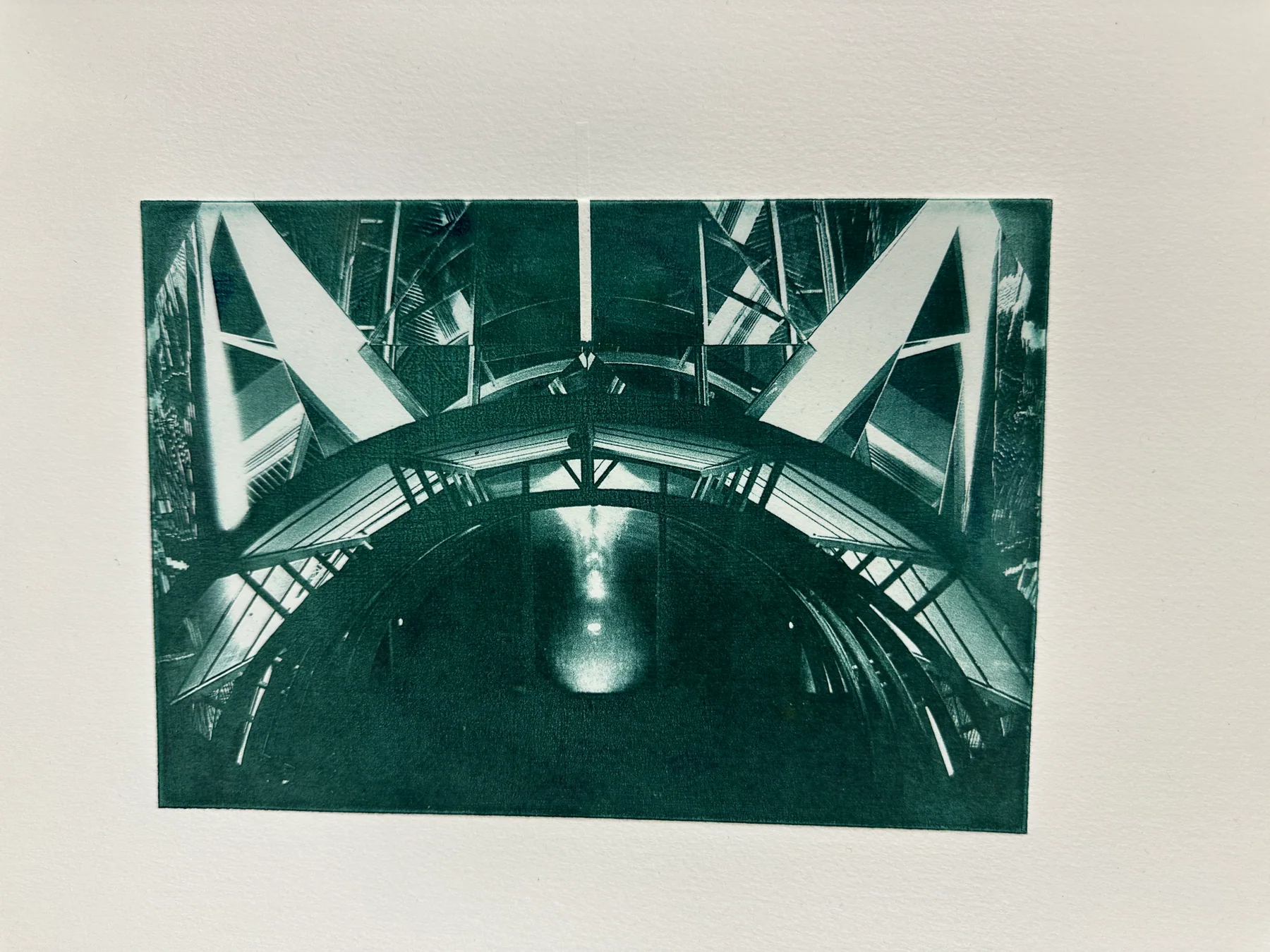 A green photogravure of a bridge and its reflection